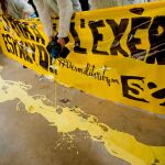 Jóvenes antililitaristas vertieron pintura amarilla en protesta por la situación de un estand del Ejército en el salón de la juventud Expojove de Girona, después de que un juez haya anulado la prohibición impuesta por la institución que acoge esta cita, Fira de Girona, en aplicación de su código ético.
