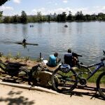 Varias personas disfrutan del buen tiempo junto al lago de la Casa de Campo de Madrid.