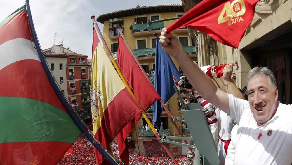 El alcalde de Pamplona, Joseba Asiron (d), tras prender desde el balcón del Ayuntamiento la mecha del cohete con el que se da inicio a las fiestas de San Fermin 2017