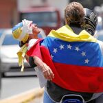 Un opositor es trasladado tras ser herido por la Policía chavista, ayer, en Caracas