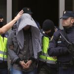 Uno de los detenidos en la operación de ayer es conducido por agentes del Cuerpo Nacional de Policía