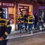 Bomberos de Madrid ante la entrada de la peluquería en La Latina