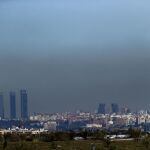 Imagen de Madrid tomada ayer con el parque empresarial de las Cuatro Torres (i), en el Paseo de la Castellana de Madrid, y las Torres Kio cubiertas por la contaminación