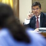 El ministro de Justicia, Rafael Catalá, mira hacia el líder de Podemos, Pablo Iglesias, durante su comparecencia en la Comisión de Justicia