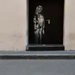 Puerta de emergencia del teatro Bataclan con la obra de Banksy