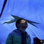 Fotografía de archivo de un niño asomado por el agujero de ventilación de una bandera gigante de la Unión Europea (UE)