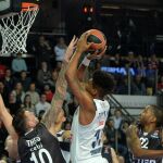 El jugador del Real Madrid Trey Thompkins (c) se dirige a la cesta ante Daniel Theis (i) del Brose Bamberg