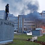 Un hombre observa un coche incendiado desde un muro donde se lee «La Policía mata», en el suburbio parisino de Bobigny
