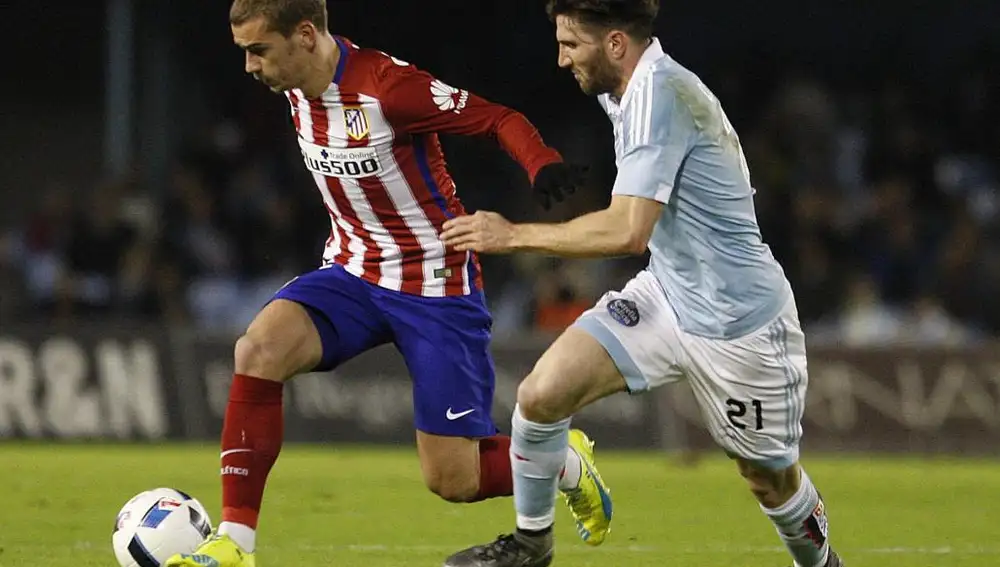 El defensa del Celta de Vigo Carles Planas (d) intenta evitar el avance del delantero francés Antoine Griezmann, del Atlético de Madrid