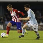 El defensa del Celta de Vigo Carles Planas (d) intenta evitar el avance del delantero francés Antoine Griezmann, del Atlético de Madrid