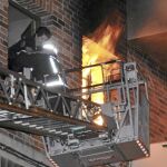Un bombero en el momento de rescatar a una de las vecinas del edificio del número 5 de la calle Coca de Segovia, afectado por la explosión de una bombona de gas butano
