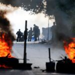 Guardias Bolivarianos permanecen a distancia de una de las barricadas levantada por los manifestantes contrarios al régimen de Maduro