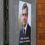 Carteles de François Fillon (C) y Jean-Luc Melenchon