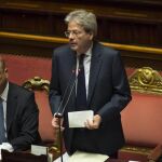 El primer ministro italiano, Paolo Gentiloni (c), toma la palabra en presencia del ministro de Asuntos Exteriores, Angelino Alfano (d), y de la ministra de Defensa, Roberta Pinotti (d), en el Senado en Roma, Italia, hoy, 14 de diciembre de 2016