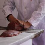 El presidente de la Unión de Vendedores de Carne de Uruguay mientras realiza cortes de bife en su carnicería en Montevideo