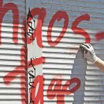 Una vecina de Hamburgo limpia una pintada resultado de los disturbios de la cumbre del G-20 del fin de semana