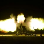 Las fuerzas de la Multitud Popular disparan contra militantes islámicos durante una batalla en Al-Hatra