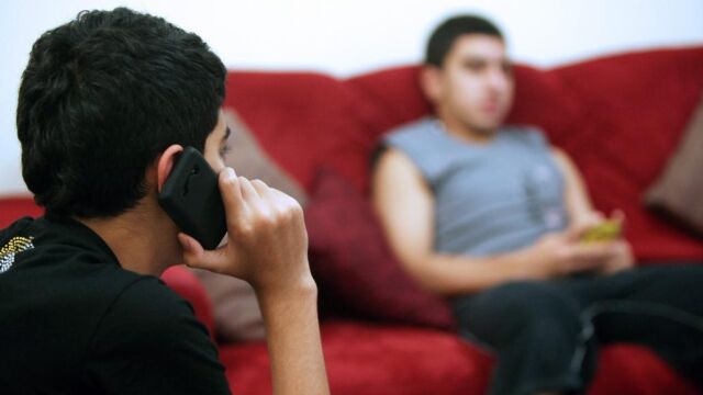 Dos menores con sus teléfonos móviles