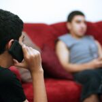 Dos menores con sus teléfonos móviles