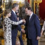 Los Reyes saludan al presidente del Gobierno en funciones, Mariano Rajoy, a su llegada a la tradicional recepción ofrecida hoy en el Palacio Real