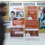 Un hombre pasa por delante de los carteles de apoyo a los tres candidatos a la Secretaría General del PSOE colocados en la sede del PSOE de Valladolid.