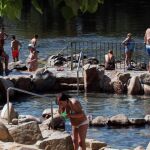 Un grupo de personas se refrescan, esta mañana, en la zona fluvial del río Miño y las termas de A Chavasqueira / Efe