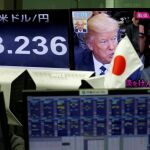 Un monitor de una casa de cambio de moneda muestra las imágenes de Trump y Abe