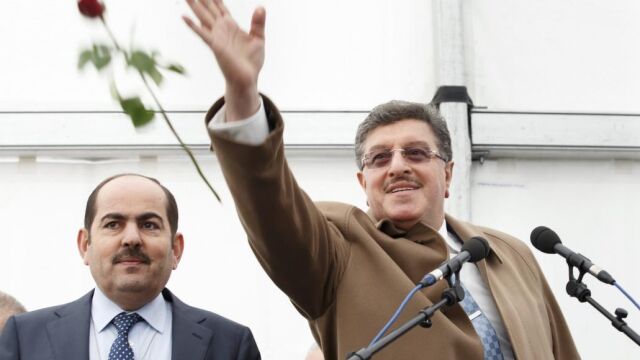 El portavoz de la oposición siria, Salem al-Meslet, lanza una rosa junto al también opositor sirio, Mustafi Abdulrahman, durante la conmemoración del quinto año de guerra en Siria
