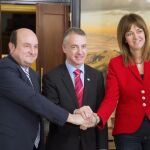 El presidente del PNV, Andoni Otuzar, el lehendakari en funciones y candidato al cargo, Iñigo Urkullu, y la secretaria general del PSE-EE, Idoia Mendia, se estrechan las manos tras haber firmado hoy el acuerdo