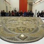 La consejera y parte del equipo multidisciplinar junto al manto de la Virgen de los Ángeles