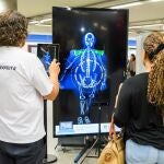 Un fisioterapeuta comprueba el reparto del peso de una pasajera del metro de Madrid