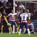 El defensa uruguayo del Atlético de Madrid, Diego Godín, remata de cabeza ante los defensas del Granada