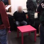 Los agentes custodian a uno de los tres detenidos