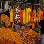 Un chico prepara guirnaldas de caléndula en un mercado de flores