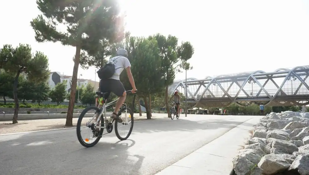 Dos ciclistas pedalean por el parque Madrid Río.