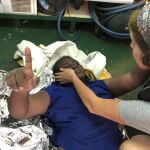 Un voluntario de Proactiva Open Arms ayuda a una mujer rescatada en la costa de Libia / Foto:Ap
