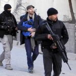 Fuerzas de seguridad escoltan a miembros de la Embajada española en su salida del edificio el día del atentado en diciembre de 2015