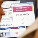 Un lector ve varias páginas digitales de los diarios mientras se abre una pantalla