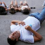 Varios turistas sofocados por las altas temperaturas descansan en las escaleras de la Catedral de la Almudena