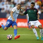 El defensa del Club Atlético Osasuna M. Flaño (d) lucha el balón con el delantero del Málaga CF, Sandro (i)