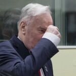 El exlider militar serbobosnio Ratko Mladic (c) levanta el puño a su entrada en la sala del Tribunal Penal Internacional para la antigua Yugoslavia (TPIY)