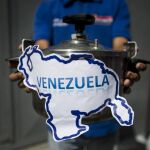 Miembros del partido político Un Nuevo Tiempo sostienen una olla a presión que simboliza la situación del país