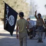 Un soldado de una de las facciones rebeldes porta una bandera capturada al Estado Islámico en el entorno de Dabiq.