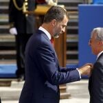 El Príncipe Felipe acompañado por el ministro del Interior, Jorge Fernández Díaz (izq.), impone la medalla de plata al director general de la Policía de Francia, Claude Baland, durante los actos centrales del Día de la Policía