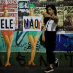 Una mujer se hace una foto con el cartel de «Él no» durante una manifestación contra Bolsonaro en Sao Paulo, Brasil, el sábado pasado