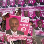 Un seguidor de Jovenel Moise, con un cartel electoral, celebra el triunfo anunciado por el Consejo Electoral