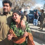 Un hombre y una mujer paquistaníes abandonan conmocionados la iglesia metodista atacada ayer por el Estado Islámico en la ciudad de Quetta