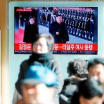 Varios peatones siguen la visita de Kim Jong Un a China en una pantalla de una céntrica calle de Seúl, capital de Corea del Sur