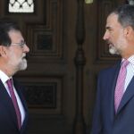 El Rey Felipe VI y el presidente del Gobierno, Mariano Rajoy, en la entrada del Palacio de Marivent, poco antes del tradicional despacho de verano