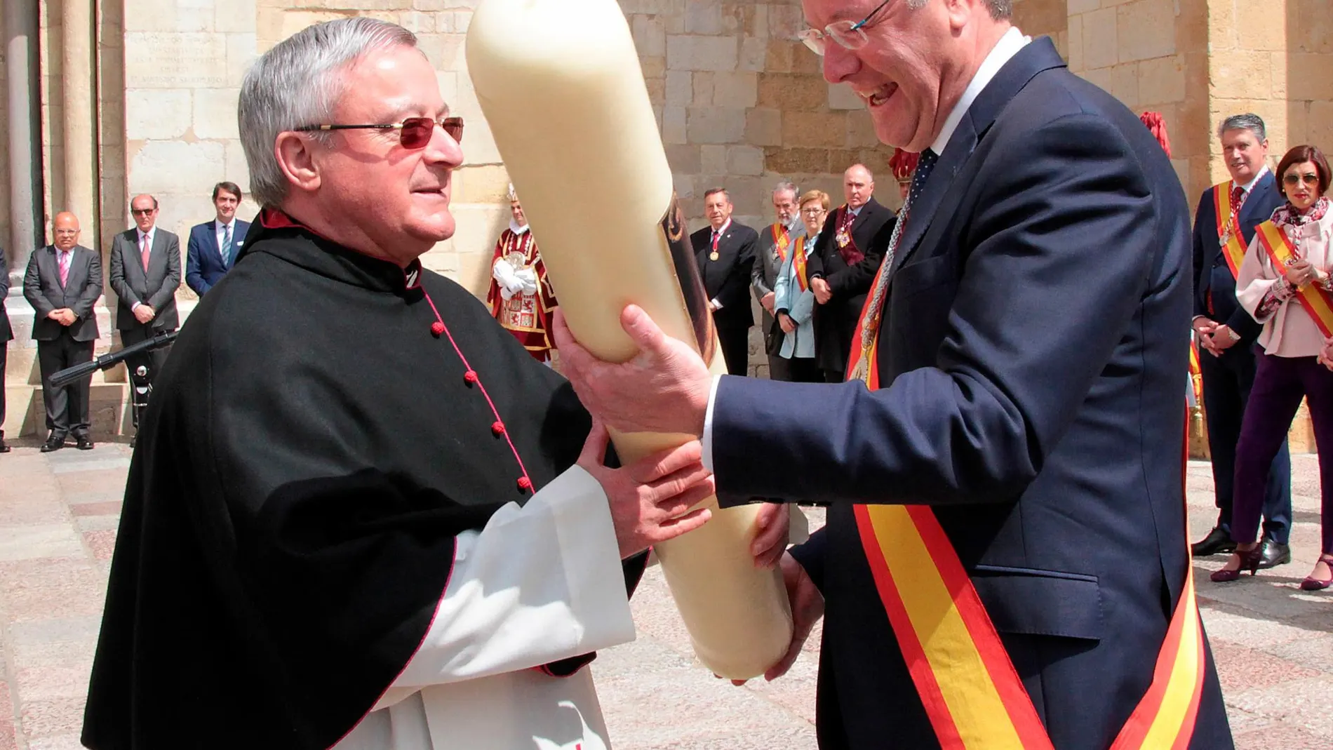 El abad de la Colegiata de San Isidoro, Francisco Rodríguez Llamazares, recibe un cirio de manos del alcalde Antonio Silván